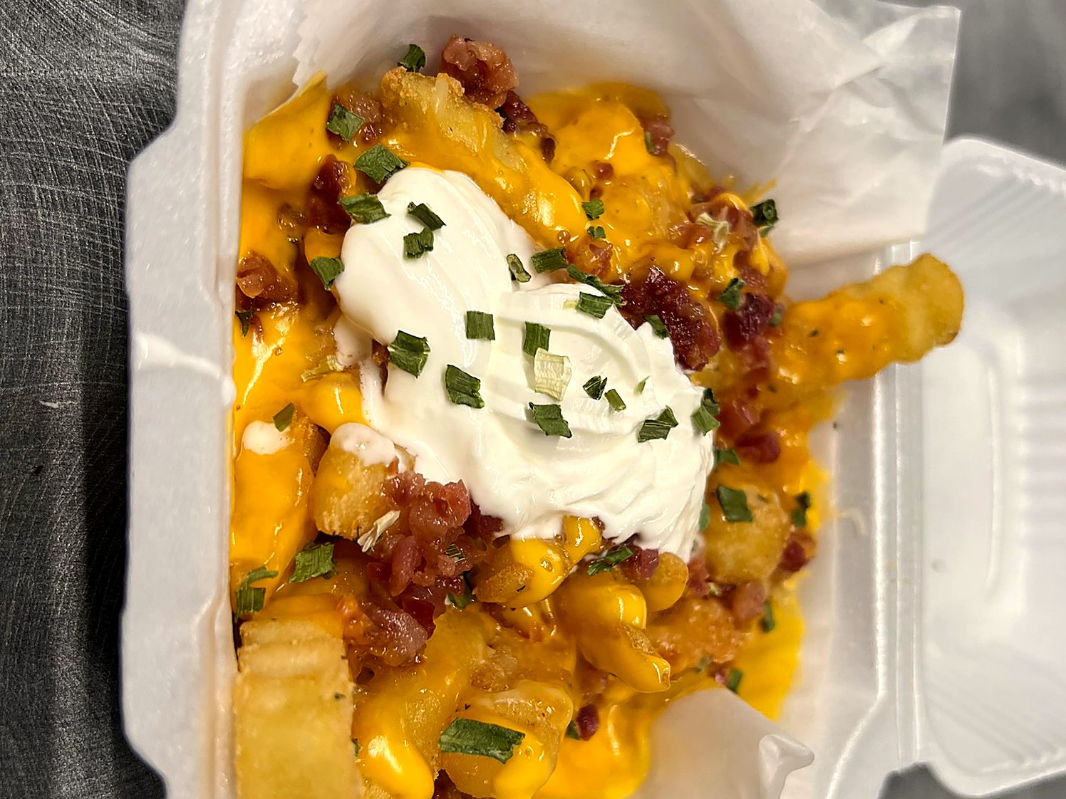 Loaded crinkle fries with cheese sauce, bacon, sour cream and chives