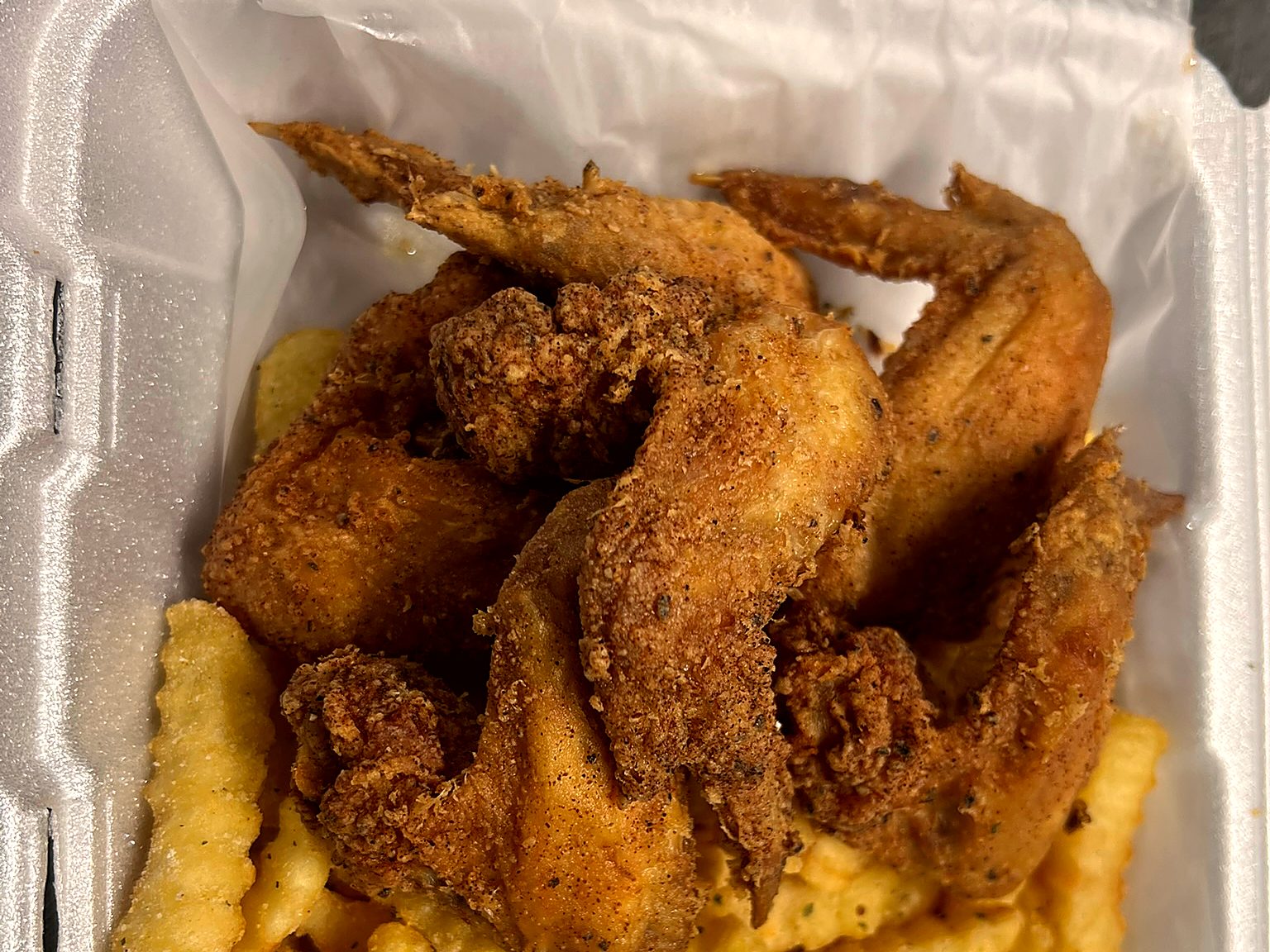 Golden breaded whole wings over seasoned crinkle fries